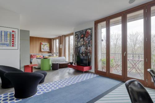 ein Wohnzimmer mit einem TV und ein Wohnzimmer mit einem Balkon in der Unterkunft Stunning Flat with Balcony - Boulogne / Paris 16 in Boulogne-Billancourt