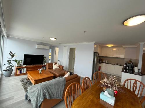 ein Wohnzimmer mit einem Sofa und einem Tisch in der Unterkunft Private room with ensuite in the CBD in Canberra