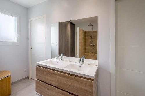 une salle de bain avec un lavabo et un miroir dans l'établissement Villa micocouliers, à Combaillaux