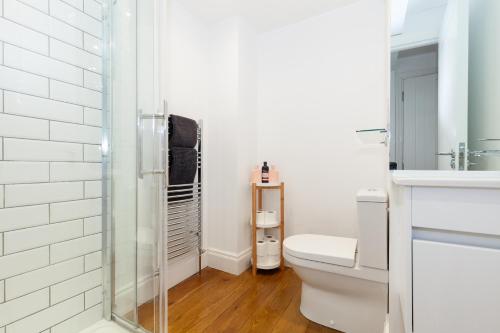 uma casa de banho com um WC e uma cabina de duche em vidro. em Trendy Terraced House in Central Oxford em Oxford