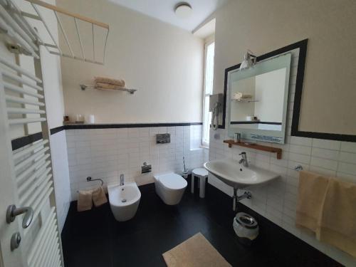 a bathroom with a sink and a toilet and a mirror at Hotel De La Plage in Pietra Ligure