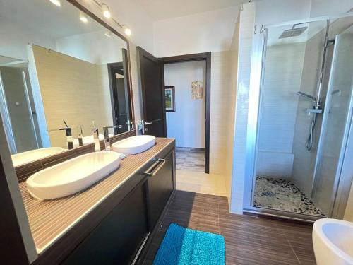 a bathroom with two sinks and a shower at H 51 Family House in Budoni
