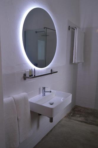 a white bathroom with a sink and a mirror at Casa Alquerque in Monsaraz