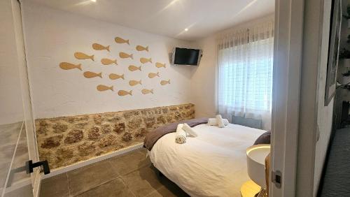 Schlafzimmer mit einem Bett mit Fisch an der Wand in der Unterkunft Bungalow Andalucia in Rincón de la Victoria