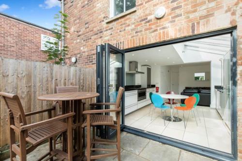 a patio with a table and chairs and a kitchen at Trendy Terraced House in Central Oxford in Oxford
