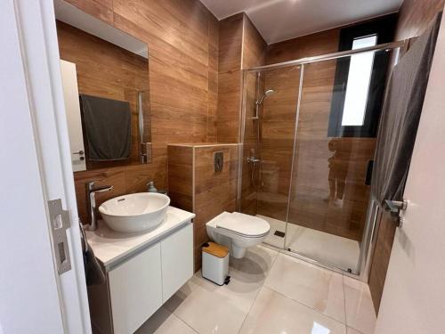 y baño con aseo, lavabo y ducha. en Cozy 3 Bedroom Apartment 300M from the SEA, en Lárnaca