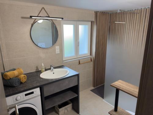 a bathroom with a sink and a mirror at Gîte Les Lilas, centre Alsace, avec jacuzzi in Mackenheim