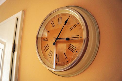 a clock hanging on a wall next to a door at Apartament Zwycięstwa in Koszalin
