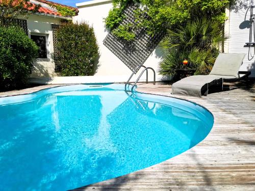 une grande piscine bleue dans une cour dans l'établissement L Oliveraie - Piscine chauffee, à Les Sables-dʼOlonne