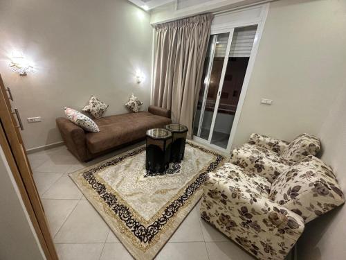 - un salon avec un canapé et une table dans l'établissement Appartement familial agadir, à Agadir
