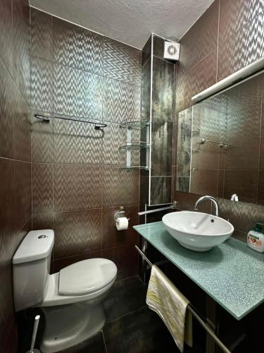 a bathroom with a white toilet and a sink at Sun Rose Apartments Sveti Stefan in Sveti Stefan