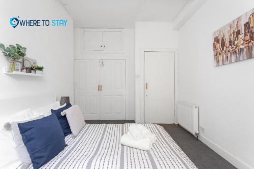 Cette chambre blanche comprend un lit et une chaise. dans l'établissement 2 Bed Apartment - 7 min walk Train Station, à Édimbourg