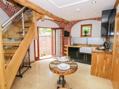 a kitchen with a wooden staircase and a table at The Hyde Dovecote Kinver pet friendly holiday let in Stourbridge