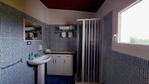 a bathroom with a sink and a toilet and a window at Il Mirto E La Rosa in Arenella