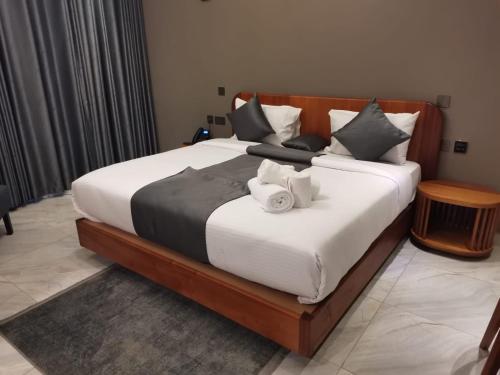 1 dormitorio con 1 cama grande con sábanas y almohadas blancas en HAVEN STAY HOTEL en Eldoret