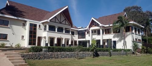Casa blanca grande con pared de piedra en HAVEN STAY HOTEL en Eldoret