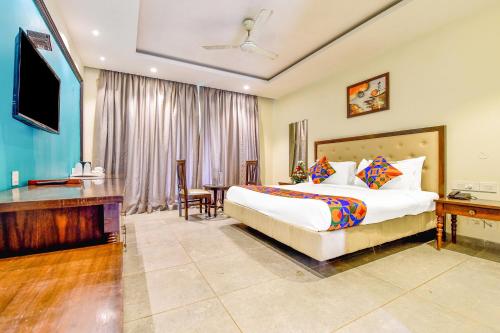 a bedroom with a bed and a desk and a television at FabHotel Prime The King's Court Calangute with Pool and Bar in Calangute