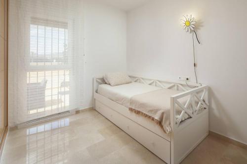 a white bedroom with a bed and a window at Relaxation, GOLF and Beach in Caleta De Velez