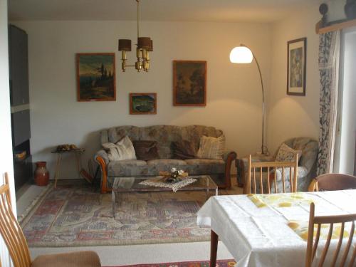 ein Wohnzimmer mit einem Sofa und einem Tisch in der Unterkunft Vogesen-Wohnung mit Balkon 2-Zi-Fewo 67qm mit herrlichem BurgVogesen-Blick neben Schlosspark Nahe in Badenweiler
