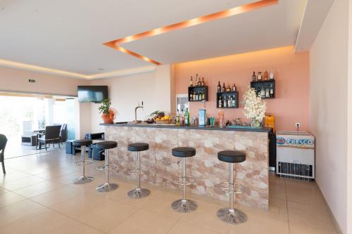 uma cozinha com um bar com bancos em frente em Crystal Blue Aparthotel em Barbati