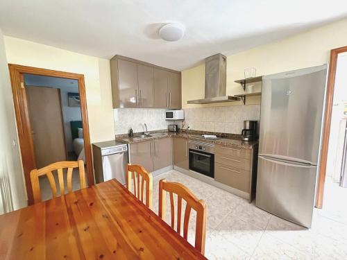 a kitchen with a wooden table and a table and chairs at CASA LORENZO in the center in Playa Blanca