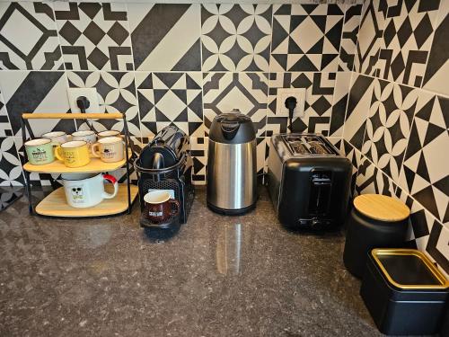 a counter with a coffee maker and coffee cups on a counter at Casa Vincente Suite-Coimbra University 1Km- 20 m2 in Coimbra