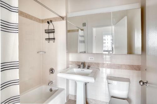 La salle de bains blanche est pourvue d'un lavabo et de toilettes. dans l'établissement UWS 1br w wd doorman gym nr Central Park NYC-1114, à New York