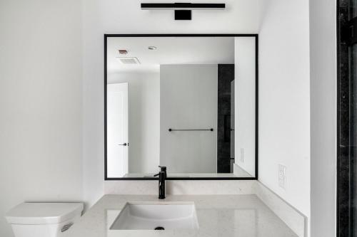 a white bathroom with a sink and a mirror at Blueground Downtown pool gym wd near food ATX-256 in Austin
