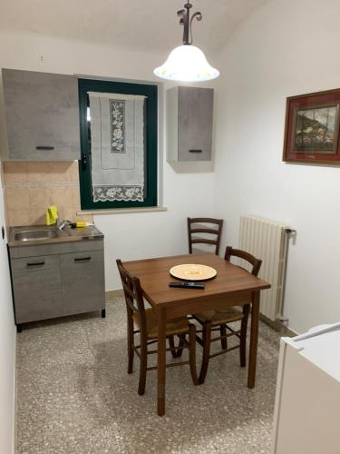 eine Küche mit einem Tisch, Stühlen und einem Waschbecken in der Unterkunft Agriturismo cerquatonda B&B in Montalto delle Marche