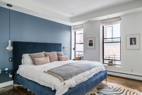- une chambre avec un grand lit et un mur bleu dans l'établissement Blueground Tribeca terrace near Battery Park NYC-1490, à New York