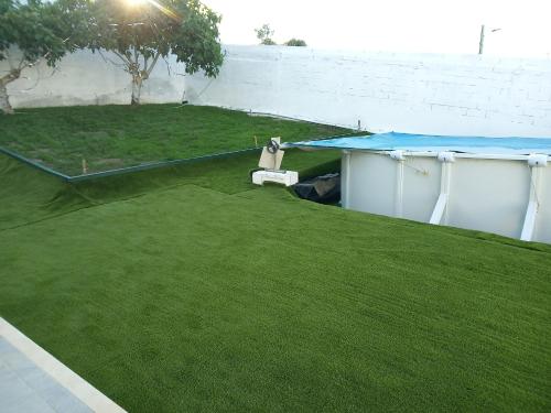 een achtertuin met groen gras en een slagkooi bij Villa Pisco in Santa Iria da Azóia