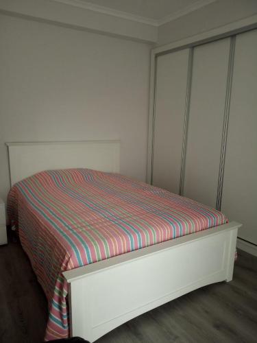 1 cama con colchón a rayas en una habitación en Villa Pisco en Santa Iria da Azóia