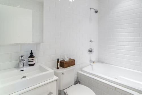 a white bathroom with a toilet and a sink at Blueground Tribeca terrace near Battery Park NYC-1490 in New York