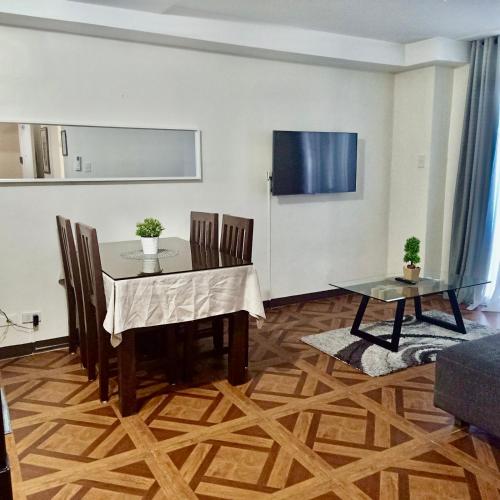 a dining room with a table and chairs and a tv at Affordable Makati APT in Manila