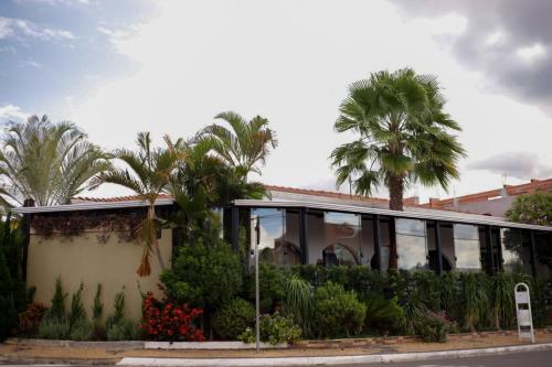 um edifício com muitas janelas e palmeiras em Pousada Rosa de Saron em Holambra