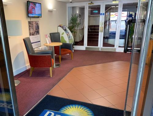 a waiting area with chairs and a table in a building at Days Inn Southampton Rownhams in Southampton