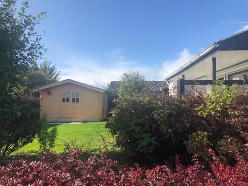 a backyard of a house with a shed at Freistehendes Ferienhaus in Eckwarderhörne mit schönem Garten in Butjadingen