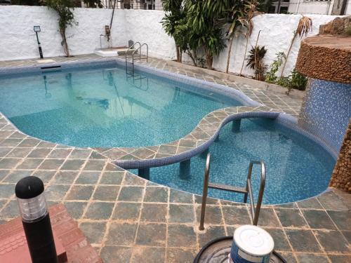 a large swimming pool with blue water in a building at SULANG Villa ECR chennai in Chennai