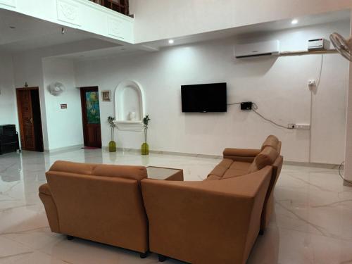 a living room with two couches and a flat screen tv at SULANG Villa ECR chennai in Chennai