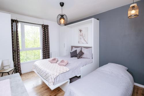 a bedroom with two beds and a window at NeuvaRoom in Montévrain