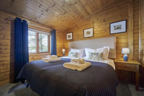 a bedroom with a bed with towels on it at Buzzard Lodge with Hot-tub in Carlisle