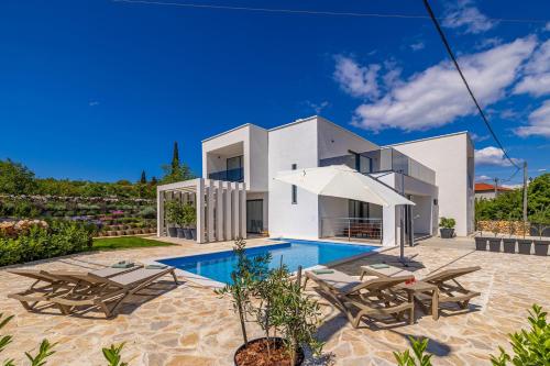 a villa with a swimming pool and chairs at Villa SPLENDIDA in Žgaljić