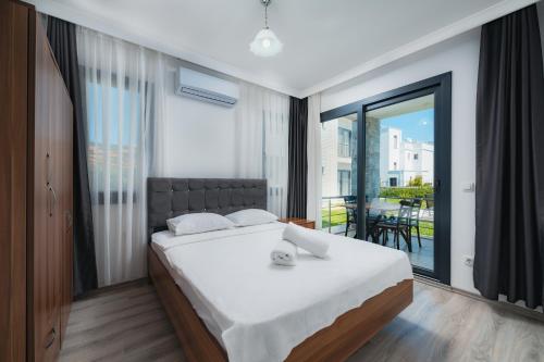 a bedroom with a large bed and a balcony at Ben Houses Family in Bodrum City