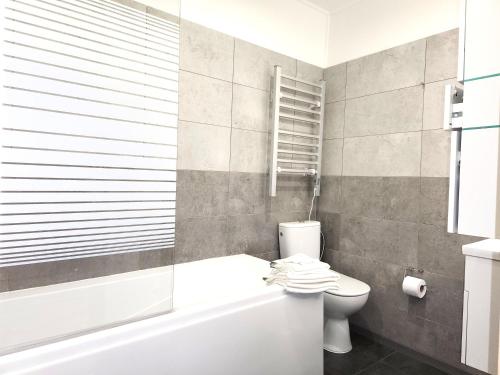 a bathroom with a toilet and a tub and a sink at Rezidence Zámeček - Boutique Hotel in Františkovy Lázně