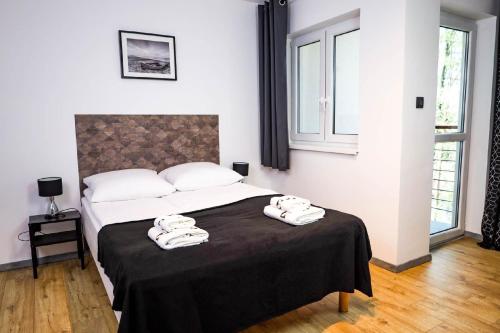 a bedroom with a bed with two towels on it at Nette Wohnung in Poddbie mit Garten, Grill und gemeinschaftlichem Pool und Strand in der Nähe in Poddąbie