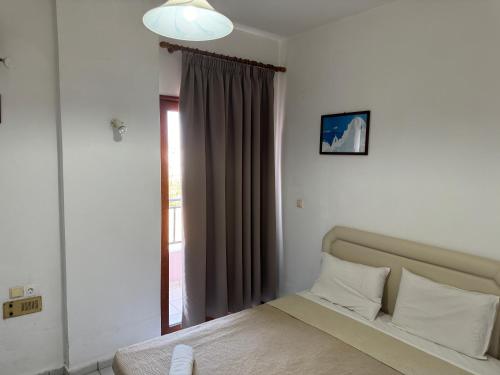 a bedroom with a bed and a large window at Zac & Georgio Studios in Amoudara Herakliou