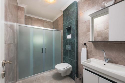 a bathroom with a shower and a toilet and a sink at Ben Houses Family in Bodrum City