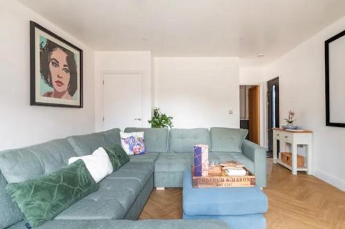 a living room with a blue couch and a table at Stargazing Filby, Norfolk Guest House in Great Yarmouth