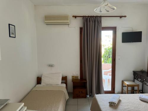 a hotel room with two beds and a window at Zac & Georgio Studios in Amoudara Herakliou