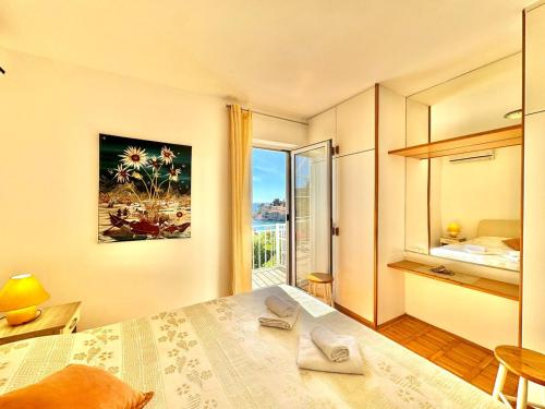 a bedroom with a bed and a large window at Sun Rose Apartments Sveti Stefan in Sveti Stefan